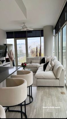 a living room filled with furniture and large windows