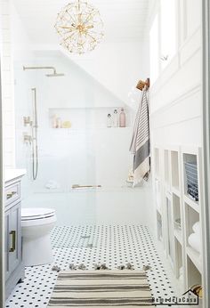 a white bathroom with black and white floor tiles