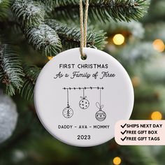 a christmas ornament hanging from a tree with the text, first christmas as a family of three