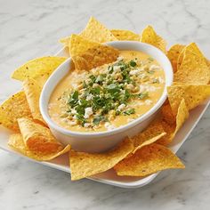 a white plate topped with tortilla chips and dip