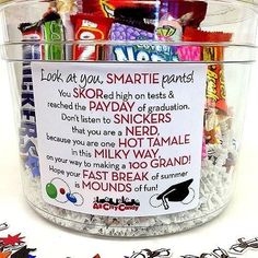 a jar filled with lots of candy sitting on top of a white countertop next to a sign that reads, look at you smart pants