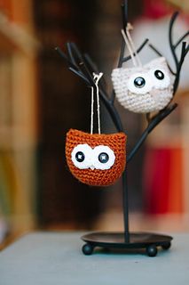 two small crocheted owls hanging from branches