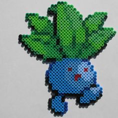 a piece of art made out of legos with green leaves on it's head