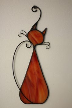 an orange and black cat is hanging on the wall