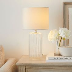 a table with a lamp, bowl and flowers on it