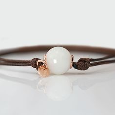 Beautiful handmade item! Here, on Etsy made as simulation only-just resin and white color.  Breastmilk pearl beaded bracelet with 1mm brown waxed cord.  Our  Simple Pearl Beads Bracelet is a pure and simple celebration of the natural beauty of motherhood. Sterling silver core in the central bead (rose or yellow gold options available). Add pearl powder for lustrous effect.  For all our breast milk bracelet collection, please visit: https://www.etsy.com/ca/shop/KeepsakeMom?ref=seller-platform-mcnav&section_id=27169694 For all breastmilk jewelry, please visit:  https://www.etsy.com/ca/shop/KeepsakeMom?ref=seller-platform-mcnav BREASTMILK JEWELRY NOTICE: For jewelry made with your own breast milk, please visit www.KeepsakeMom.com ETSY PROHIBITS THE SALE OF JEWELRY MADE WITH BREAST MILK; We se Everyday White Waxed Cord Bracelets, Handmade White Jewelry With Waxed Cord, White Waxed Cord Bracelet Perfect For Gifting, White Waxed Cord Bracelet As A Gift, White Waxed Cord Bracelets For Gifts, Breastmilk Jewelry, Silver Core, Simple Pearl, Pearl Powder