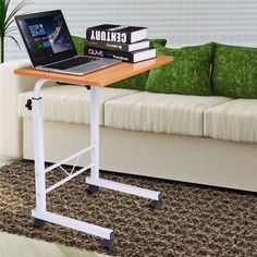 a laptop computer sitting on top of a wooden table in front of a white couch