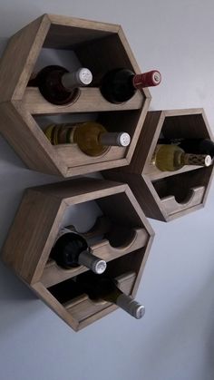 three hexagonal wooden wine racks holding bottles