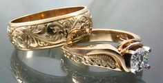 two gold wedding rings sitting next to each other