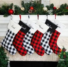 three christmas stockings hanging from a mantel decorated with greenery and red plaid stocking