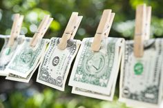 dollar bills are hung on clothes pins to dry