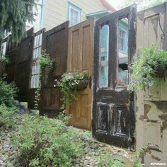 a row of houses with wooden doors and window boxes on the side of each building