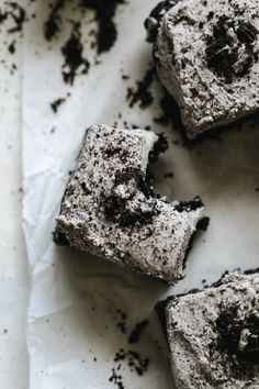 four pieces of cake sitting on top of a piece of wax paper covered in dirt