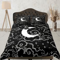 a black and white bed set with clouds, stars and the moon in the sky