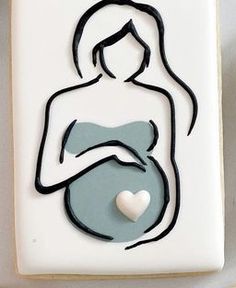 a cookie with a cut out of a pregnant woman holding a heart