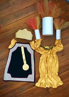 the costume and accessories are laid out on the wooden floor next to toilet paper rolls