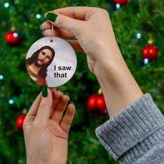 a person holding up a christmas ornament with a dog on it's side