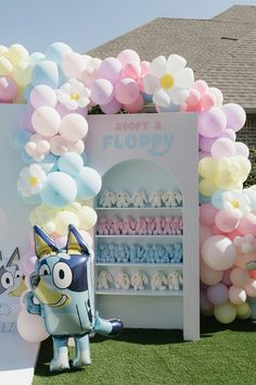 balloons and stuffed animals are on display in front of a sign