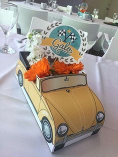 an old car is decorated with flowers on the table