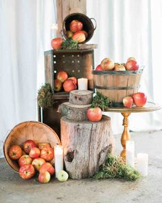 an arrangement of apples and candles on a table