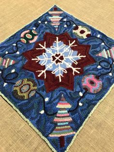 a close up of a blue and red rug with snowflakes on it