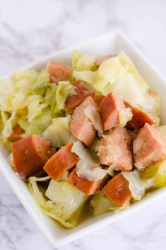 a white plate topped with meat and cabbage