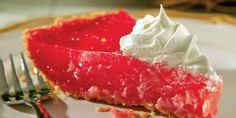 a slice of strawberry pie with whipped cream on top and fork next to the plate