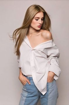 a woman with long hair wearing jeans and a white shirt is posing for the camera