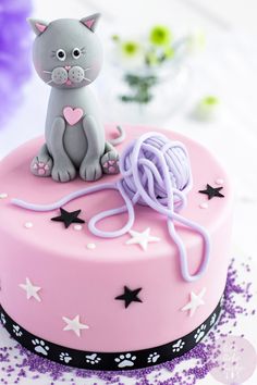 a cake decorated with a cat and yarn