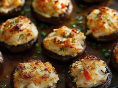 an assortment of stuffed mushrooms with cheese and herbs on the top, ready to be eaten