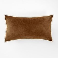 a brown and white pillow sitting on top of a bed