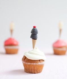 cupcakes with white frosting and red icing topped with an individual figurine