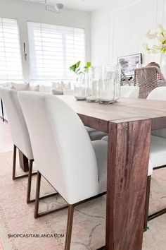 a dining room table with white chairs around it