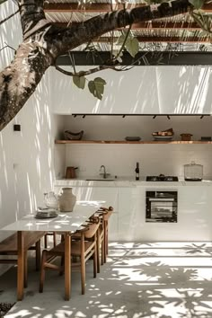 an outdoor kitchen and dining area is shown in this image, with the sun shining through the trees