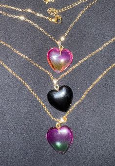 These beautiful glass pendants come in solid black heart, gradient pink yellow heart (see through) and purple green heart (see through).  An 18k gold plated stainless steel chain completes the look.  The glass heart necklace is great for any occasion and gift giving.   It will make a unique addition to anyone's jewelry collection. Product info: *Glass heart pendant is ~2 cm x ~2 cm *18k gold plated stainless steel link cable chain necklace fully extended is ~18 inches *Hypoallergenic and good for sensitive skin *Sold as glass heart pendant and chain necklace together *Color variation and shade can be expected in glass beads. *Please be aware that colors and brightness can vary slightly on different various screening devices. Shipping info: *Ready to ship *All packages shipped via USPS with Trendy Heart Cut Jewelry Gift, Trendy Heart Cut Jewelry For Gifts, Trendy Purple Jewelry With Heart Beads, Trendy Heart Pendant Jewelry With Heart Print, Trendy Gold Jewelry With Heart Print, Trendy Heart Print Jewelry For Gifts, Purple Heart-shaped Jewelry For Party, Heart Shaped Purple Jewelry For Party, Heart-shaped Purple Jewelry For Party