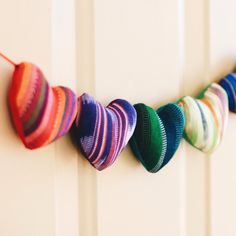 multicolored heart shaped items hanging on the side of a door with string attached to it