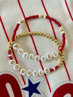 - Calling all Phillies fans! Personalize your custom Philadelphia Phillies bracelet for game day. Choose from classic red seed bead with 18k gold accents, full gold beaded beaded with red accents or get a set. Gold filled beads are much more tarnish resistant and long lasting, opposed the the more commonly seen gold plated. These bracelets layer well with others so add this to your stack for your next tailgate! Beaded on high quality stretch cord and secured. - Listing is for (1) bracelet or set of (2). Set includes (1) gold beaded bracelet with red accent and (1) seed bead bracelet.  -  4mm 18k gold filled beads       3mm glass seed beads     acrylic letter beads      -  Enter your own customization in personalization box. Feel free to message me with any questions. - Each purchase is sen Personalized Red Name Bracelet With Round Beads, Personalized Adjustable Red Name Bracelet, Personalized Red Adjustable Name Bracelet, Red Name Bracelet With Letter Beads For Gift, Adjustable Personalized Red Stretch Bracelet, Customized Red Wristband For Gift, Red Adjustable Personalized Stretch Bracelet, Red Adjustable Stretch Bracelet, Personalized, Red Custom Name Bracelet For Friendship