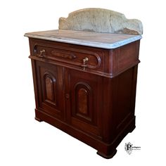 an old fashioned wooden cabinet with marble top