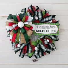 a golf themed wreath hanging on the side of a wall with a sign that says we are not home