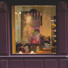 Arrow Heart Retail Shop Window Vinyl. A heart in the centre with the arrowheads pointing in to the heart. Shown in pink on a window. Heart Window, Jungle Decorations, Arrow Heart, Shop Window Stickers, Shop Inspiration, Retail Windows, Colour Chart, Shop Window Displays