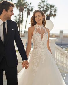 a bride and groom hold hands as they walk together