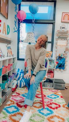 a woman sitting on top of a chair in a room filled with toys and decorations