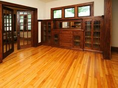 an empty room with wooden floors and windows