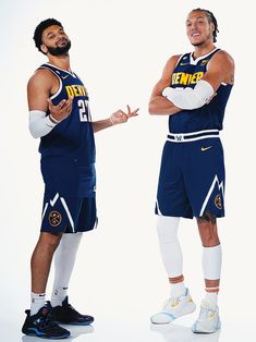 two basketball players standing next to each other with their arms crossed in front of them