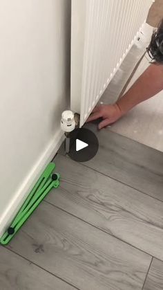 a person is opening the radiator on the floor with a green hose attached to it