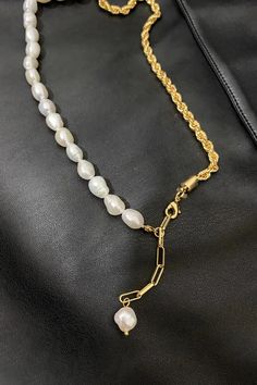 Pearl & Chain: A Symphonic Dance of Tradition and Trend Meticulously selected man-made pearls pair with a uniquely twisted chain design, radiating a harmonious blend of vintage allure and contemporary appeal. The pearls' natural luster complements the metallic sheen of the twisted chain, offering a touch of minimalist cold-chic vibe. This simplistic yet captivating design seamlessly fits with everyday wear or special occasions, effortlessly accentuating your persona and elegance. The necklace si Pearl Lariat Chain Jewelry, Adjustable Pearl Necklace With Chain, Pearl Lariat Jewelry With Chain Detail, Gold Pearl Chain Necklace In Metal, Pearl Lariat With Chain Detail Jewelry, Half Chain Half Pearl Necklace, White Lariat Pearl Chain Necklace, Pearl Lariat Necklace With Chain Detail, Elegant White Rope Chain Necklace