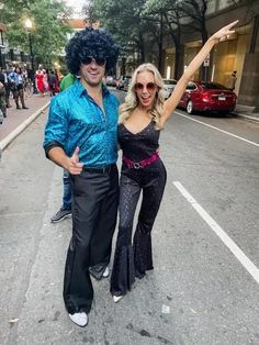 a man and woman dressed up in costume posing for a photo on the side walk