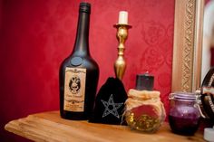 some bottles are sitting on a shelf in front of a mirror with candles and other items