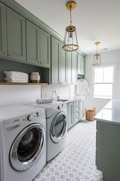 a washer and dryer in a room with green cabinets