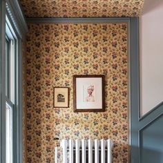 a room with wallpaper and a radiator next to a painting on the wall